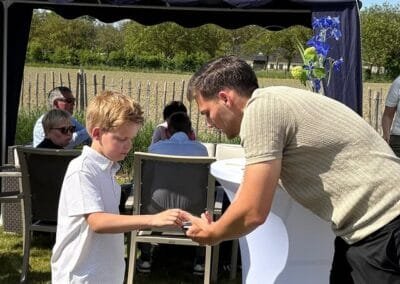 Goochelaar voert interactieve magie uit voor een kind tijdens een zomers evenement in openlucht