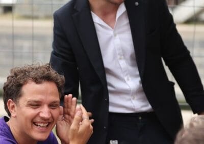 Wout staat al glimlachend bij gasten op een event
